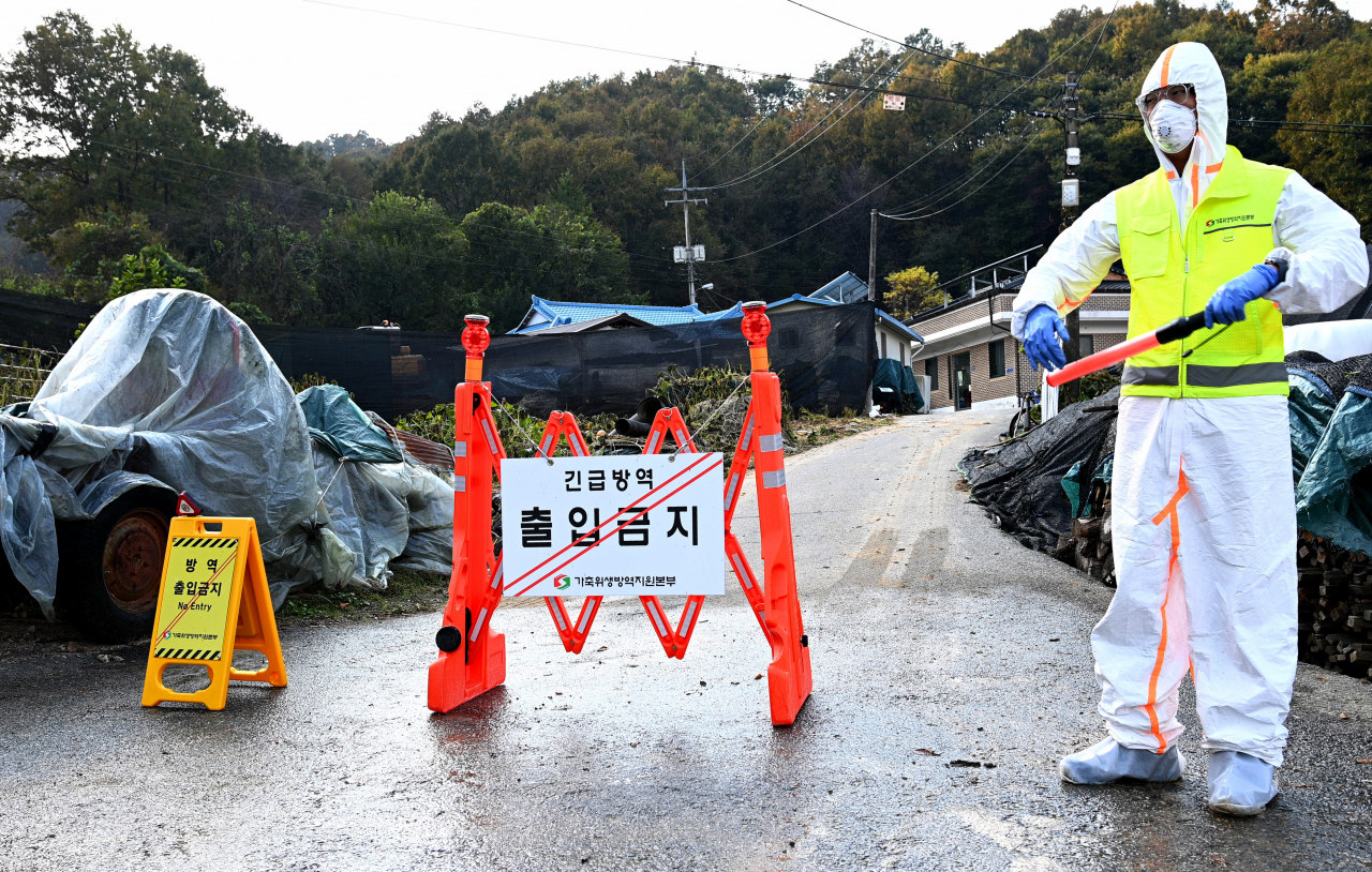 On Monday, an official controls entry to a farm in Eumseong, 84 kilometers southeast of Seoul. (Provincial government)