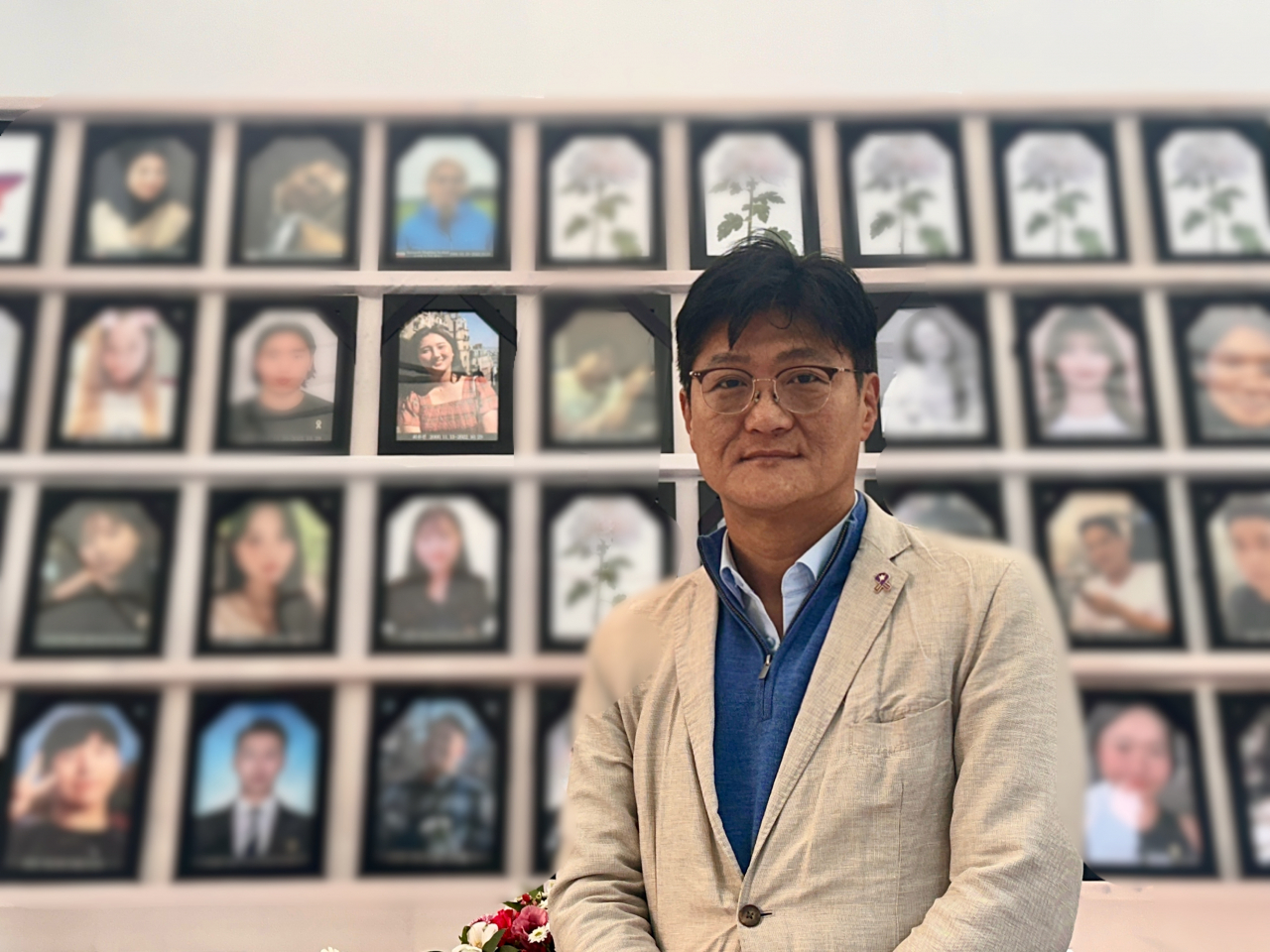 Choi Joung-joo, the father of the late Choi Yu-jin, takes a photo with Choi Yu-jin's portrait at the makeshift memorial near Seoul City Hall. (Lee Jung-joo/The Korea Herald)