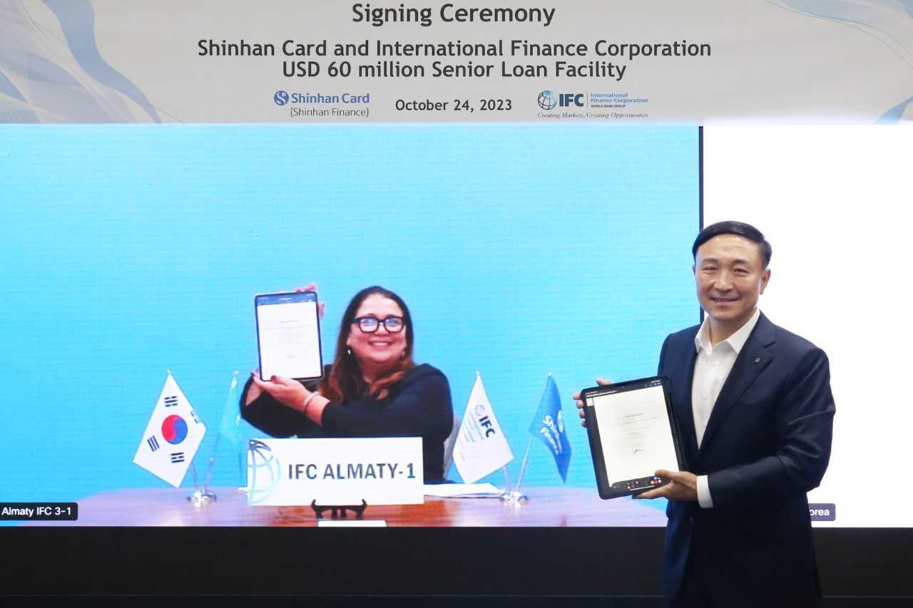 Shinhan Card CEO Moon Dong-kwon (right) and Momina Aijazuddin, principal investment officer at IFC's Financial Institution Group, pose for photos during a signing event for the new funding on Tuesday. (Shinhan Card)
