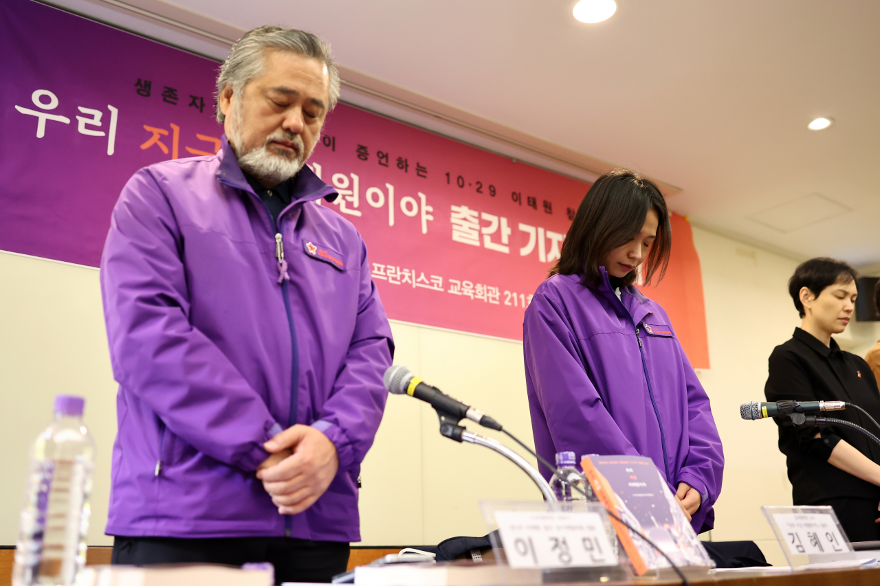 Lee Jeong-min, (left) who lost his daughter in Itaewon, and Kim Hye-in, who lost her brother, hold a moment of silence before a press conference in Jung-gu, Seoul, on Wednesday. (Yonhap)