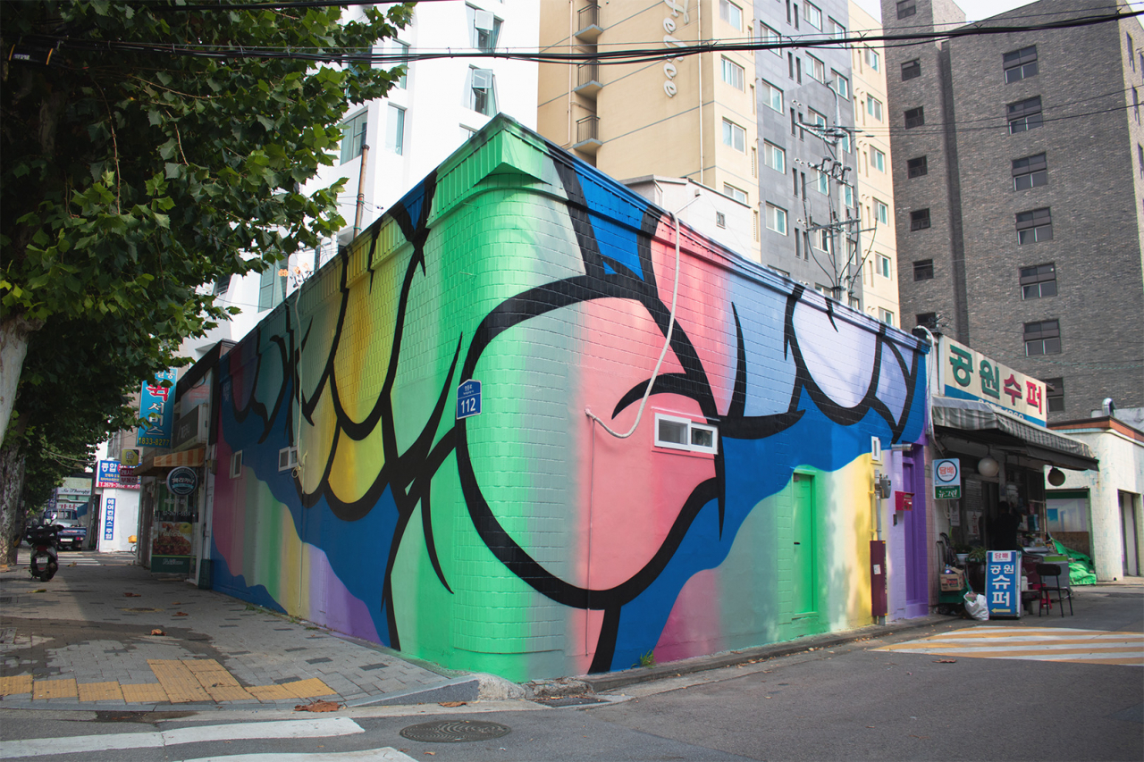 Mr. Tongue's mural is sandwiched between old shops and new buildings in Yeongdeungpo-gu, Seoul. (Tammy Park/The Korea Herald)