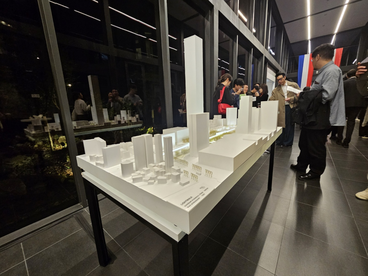 Visitors take a look at a architectural design model of the Lightwalk project on Thursday at the French Embassy in Seoul. (Park Yuna/The Korea Herald)