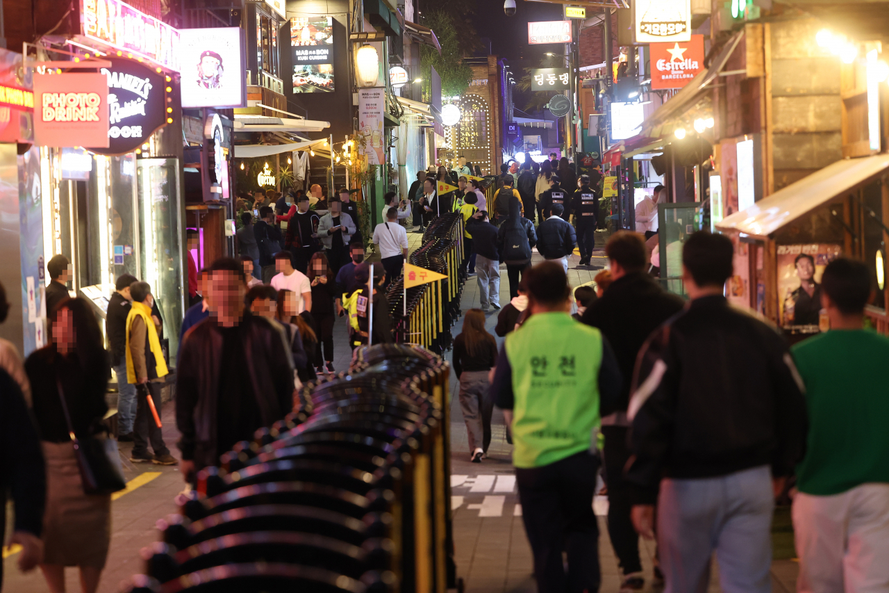 A 300-meter-long barricade is set up to divide the crowd going in and out of the alley in Itaewon World Food Street on Saturday. (Yonhap)