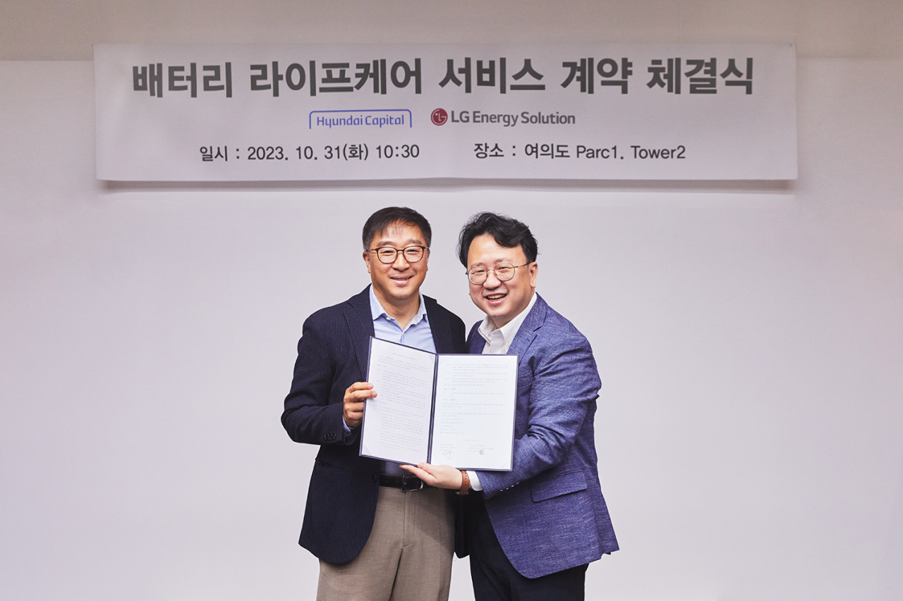 Shim Jang-soo (left), director of Hyundai Capital's auto business unit, and Kim Tae-young, head of LG Energy Solution's service business development task team, pose for a photo at the partnership signing ceremony for the launch of the Battery Lifecare service in Yeouido, Seoul, Tuesday. (LG Energy Solution)