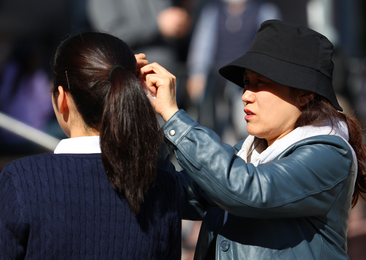 A parent speaks to her daughter at the Hankuk University of Foreign Studies campus in Seoul, where admission interviews were held on Oct. 29. (Yonhap)