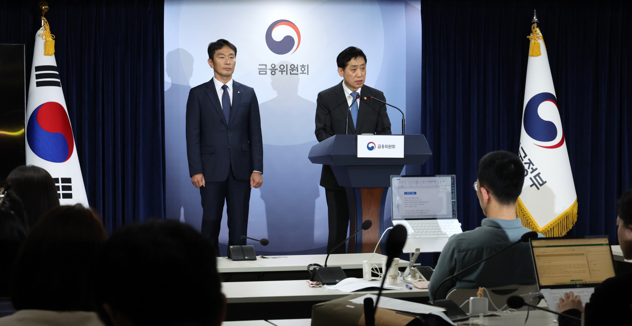 Kim Joo-hyun (right), head of the Financial Services Commission, and Lee Bok-hyun, chief of the Financial Supervisory Service, hold a joint press briefing in Seoul on Sunday. (Yonhap)