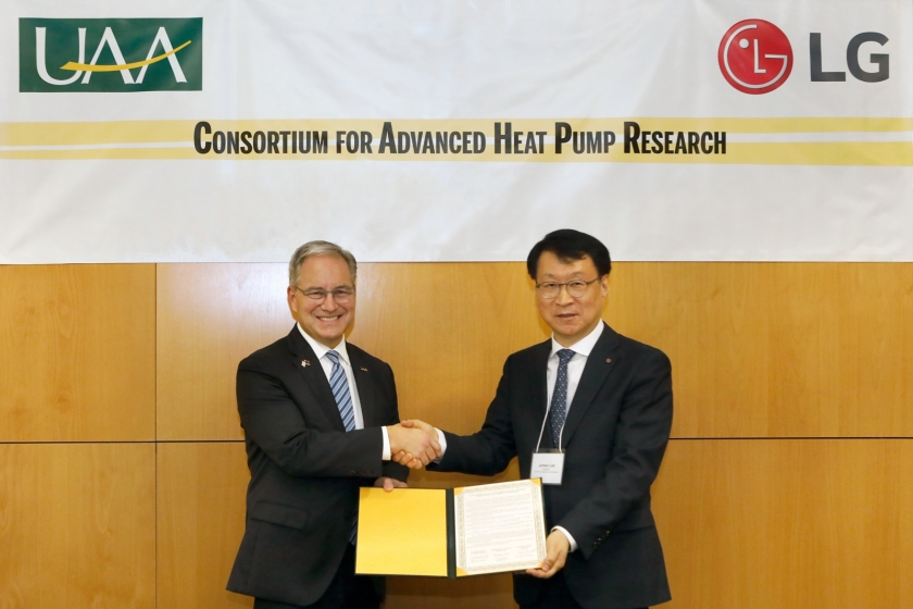 Sean Parnell (left), chancellor of the University of Alaska Anchorage, and Lee Jae-seong, head of LG Electronics’ air solution business division, shake hands during a partnership signing event at the US school's campus in Anchorage, Alaska. (LG Electronics)