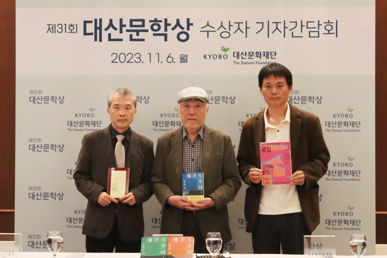 From left: Poet Kim Ki-taek, novelist Hyun Ki-young and director Yi Yang-gu pose for a group photo during a press conference held in Seoul, on Monday. (The Daesan Foundation)