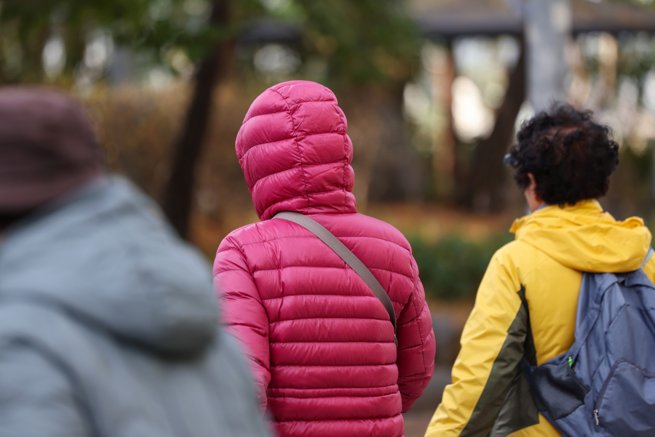 People wear thick jackets to ward off the cold in Seoul on Tuesday. (Yonhap)