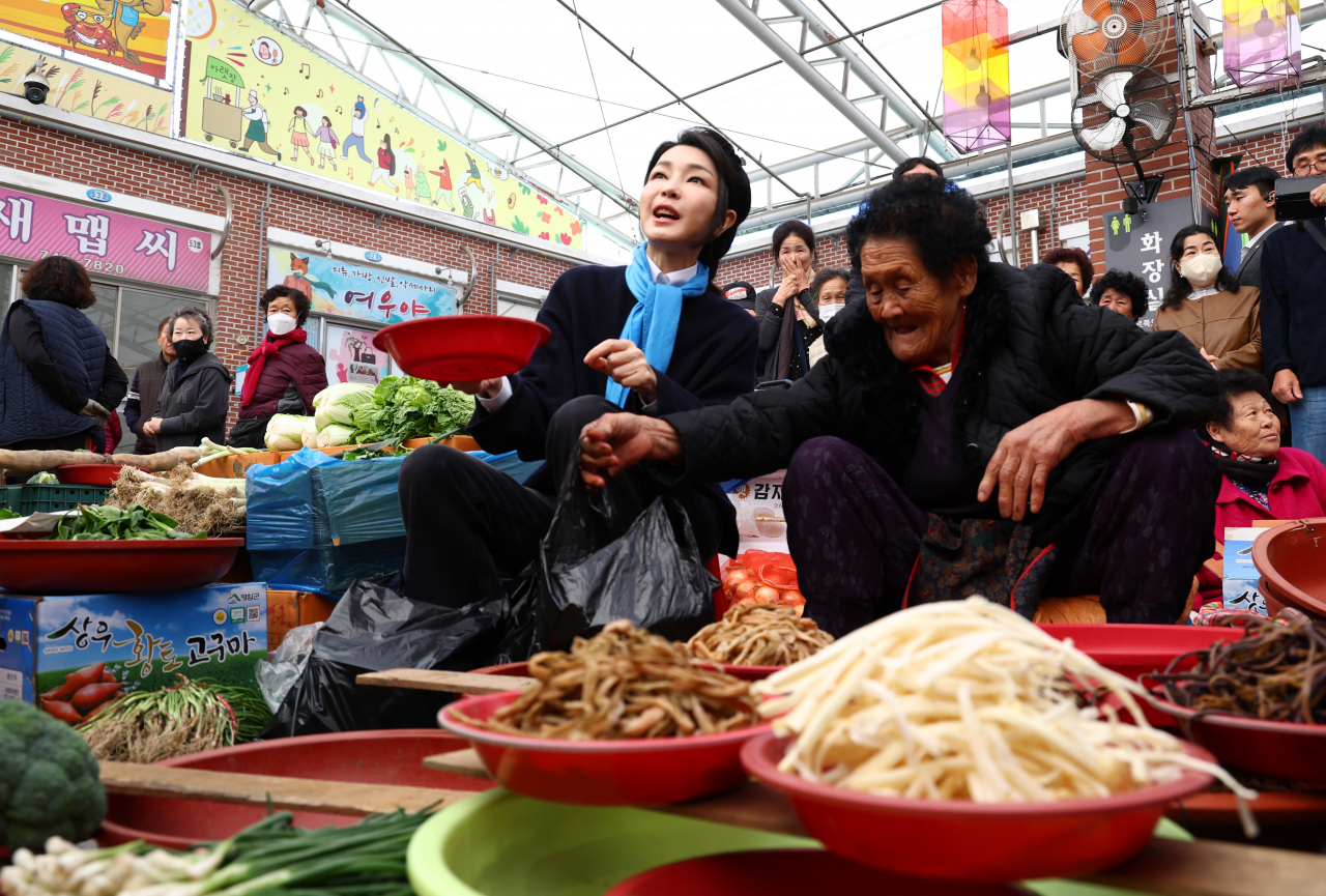 First lady Kim Keon Hee (left) purchases vegetables at a traditional market in Suncheon, 286 kilometers south of Seoul, on Tuesday. (Yonhap)