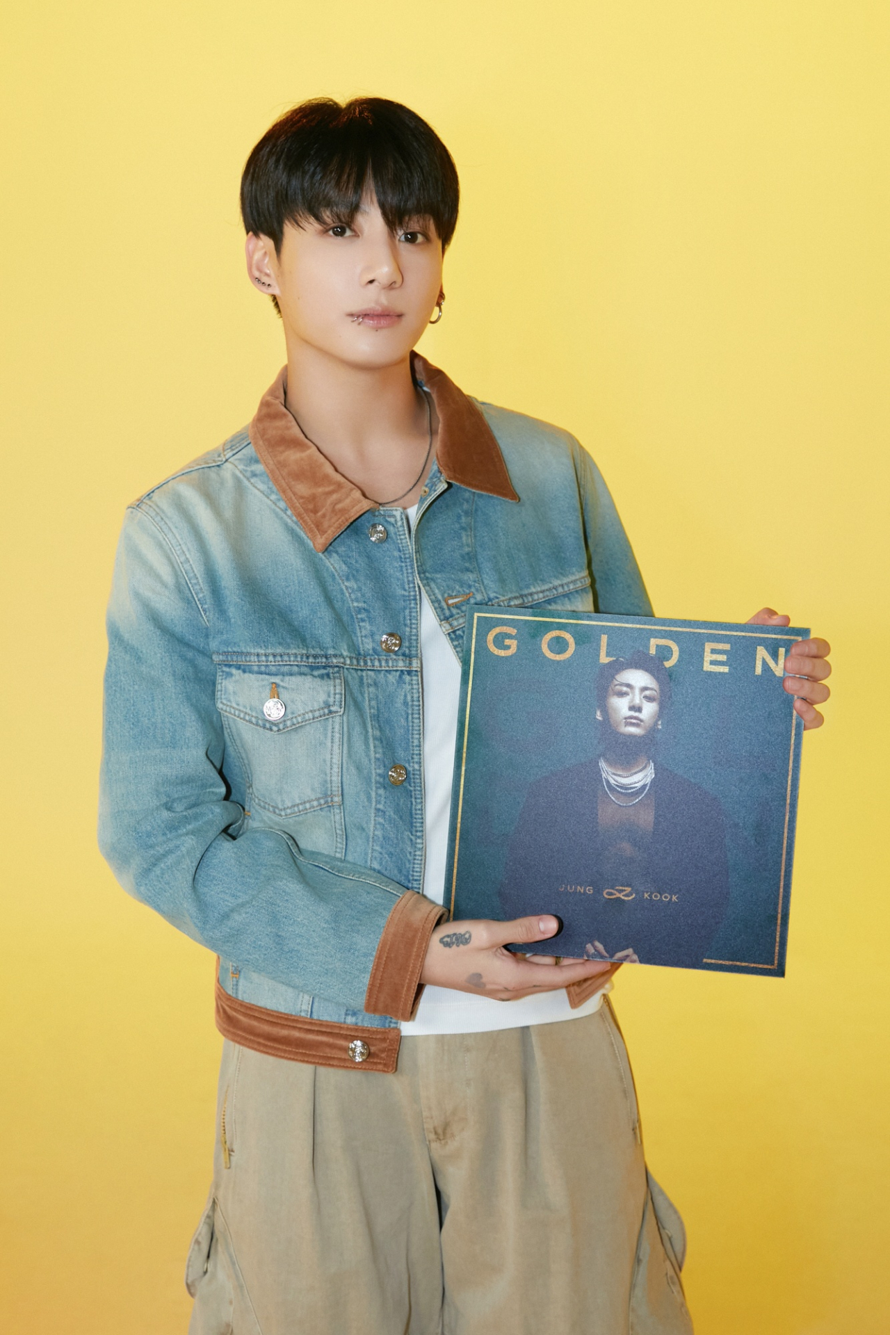 An image of BTS' Jungkook holding his first solo album 