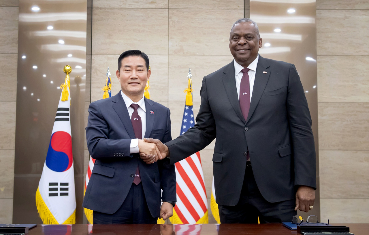 South Korean Defense Minister Shin Won-sik (left) and US Secretary of Defense Lloyd Austin pose for a photo after signing the revised document of the Tailored Deterrence Strategy during the 55th Security Consultative Meeting at the Ministry of National Defense in Seoul on Monday. The two ministers attended the ceremony both donning burgundy-colored ties to signify the countries' 