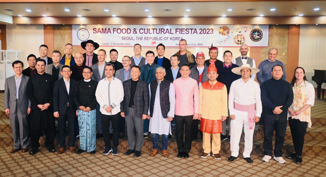 A group of foreign defense attachés from the Seoul Association of Military Attaches (SAMA) in South Korea pose for a photo at an event held to celebrate SAMA Food & Cultural Fiesta 2023 at the Army Club in Yongsan-gu, Seoul, on Saturday. The event was attended by 18 embassies with their military attaché and family members, members of the diplomatic corps, foreign residents in Korea, and the media. 17 countries, including South Korea, represented their cultures during the event. (Sanjay Kumar/The Korea Herald)