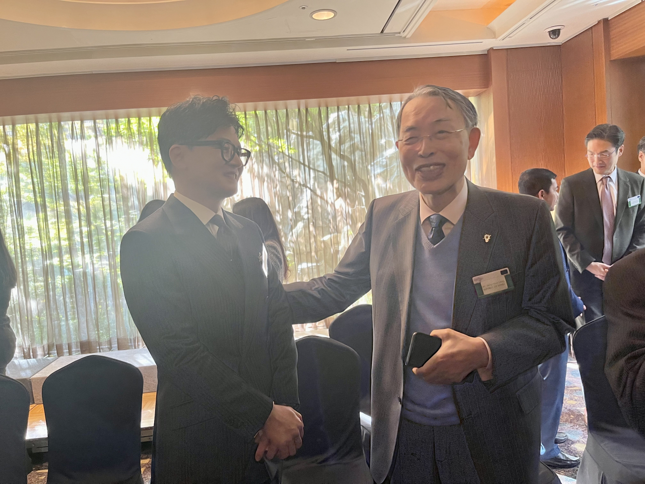 Minister of Justice Han Dong-hoon and former ICC chief Song Sang-hyun greet one another at the seminar at a hotel in central Seoul on Tuesday. (Kim Arin/The Korea Herald)