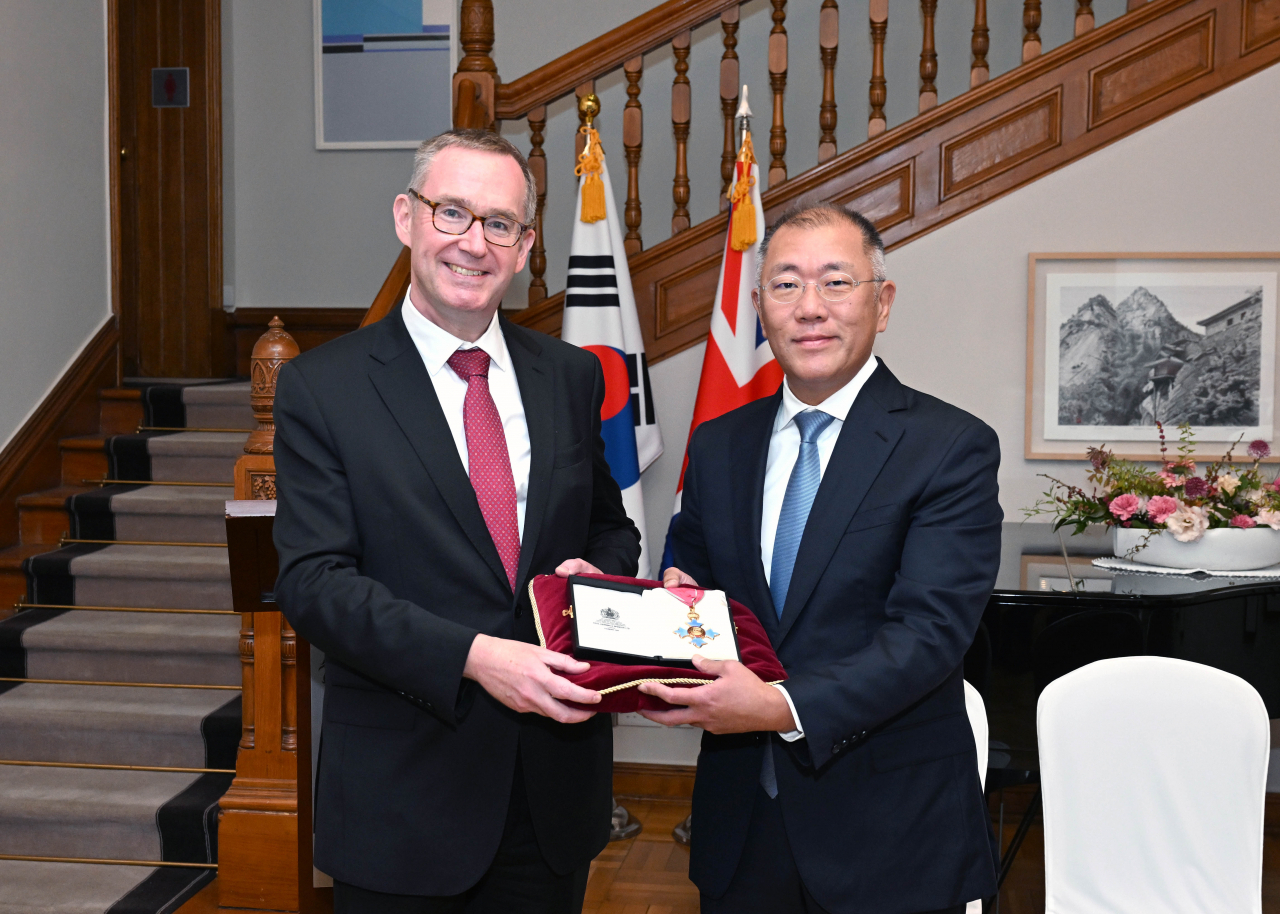 Hyundai Motor Group Executive Chair Chung Euisun (right) receives the Honorary Commander of the Most Excellent Order of the British Empire medal from Colin Crooks, British Ambassador to the Republic of Korea, at the British Embassy in Seoul on Tuesday. (Hyundai Motor Group)