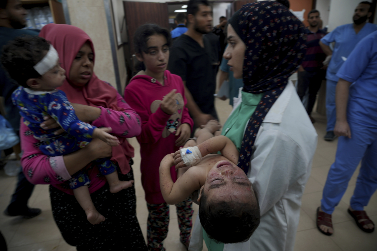 Palestinians wounded in the Israeli bombardment of the Gaza Strip are brought to a hospital in Deir al-Balah on Tuesday. (AP-Yonhap)