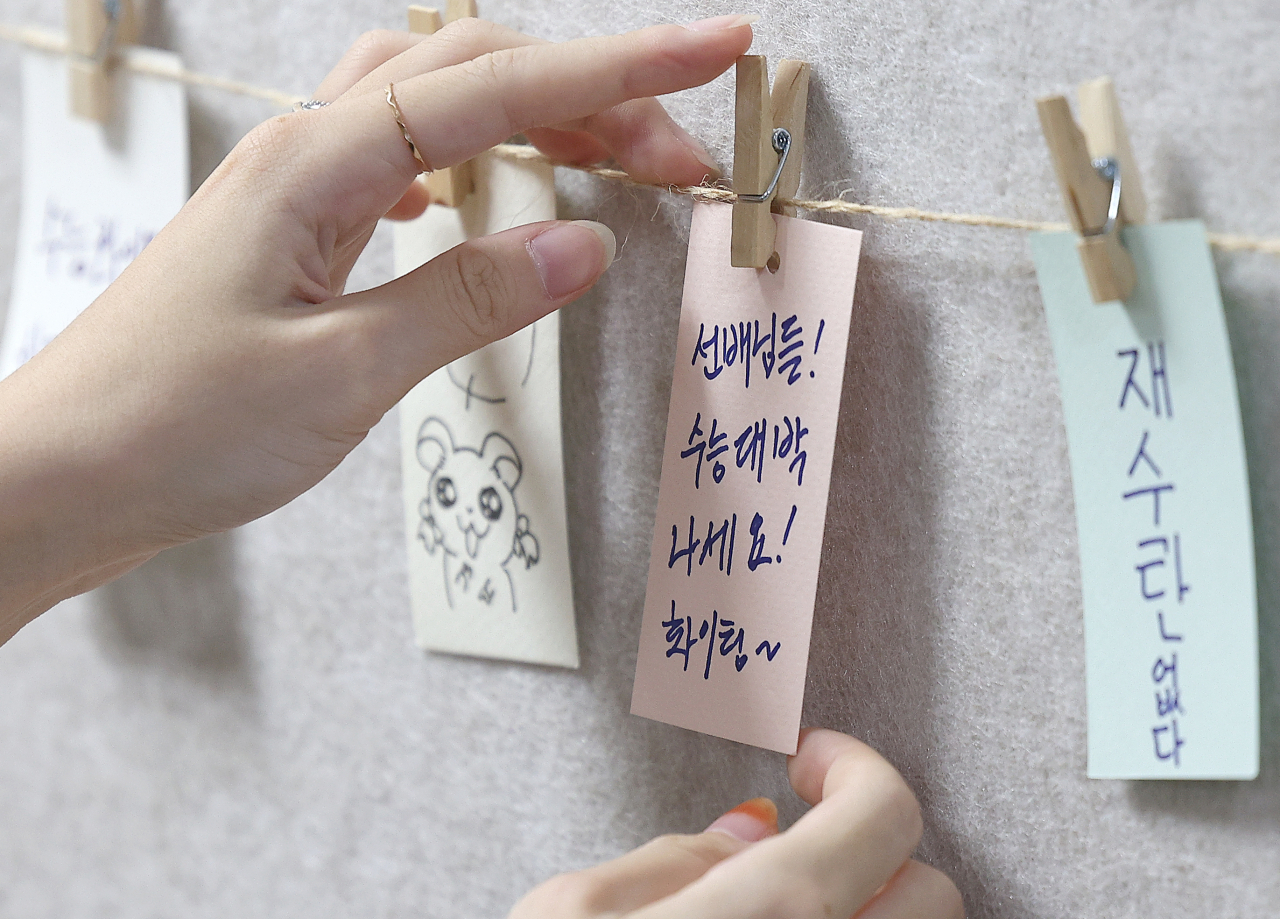 On Nov. 6, 10 days before this year's Suneung, students post messages of support for those taking the test on a bulletin board. (Yonhap)