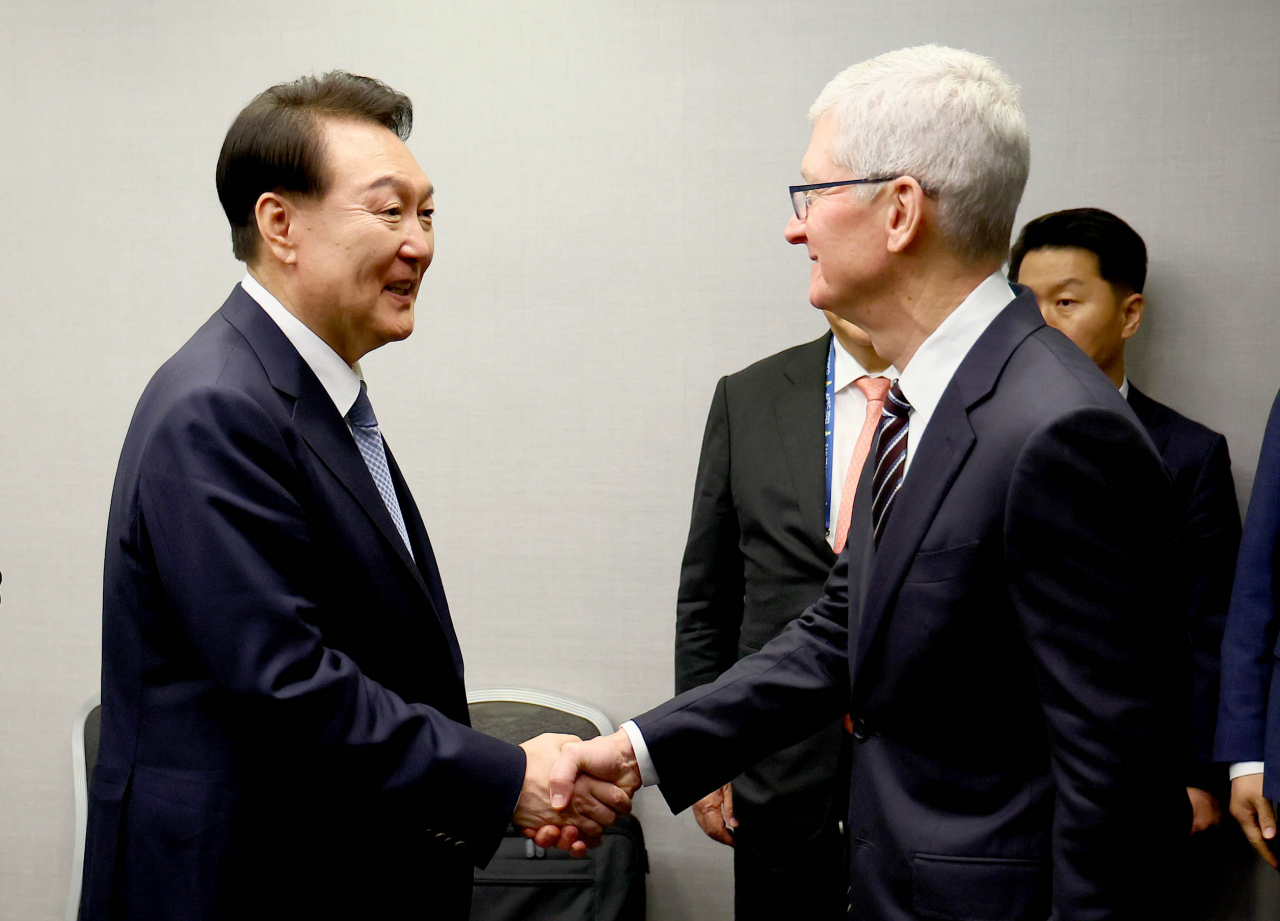 President Yoon Suk Yeol (right) shakes hands with Apple CEO Tim Cook before a meeting in San Francisco on Wednesday. (Yonhap)