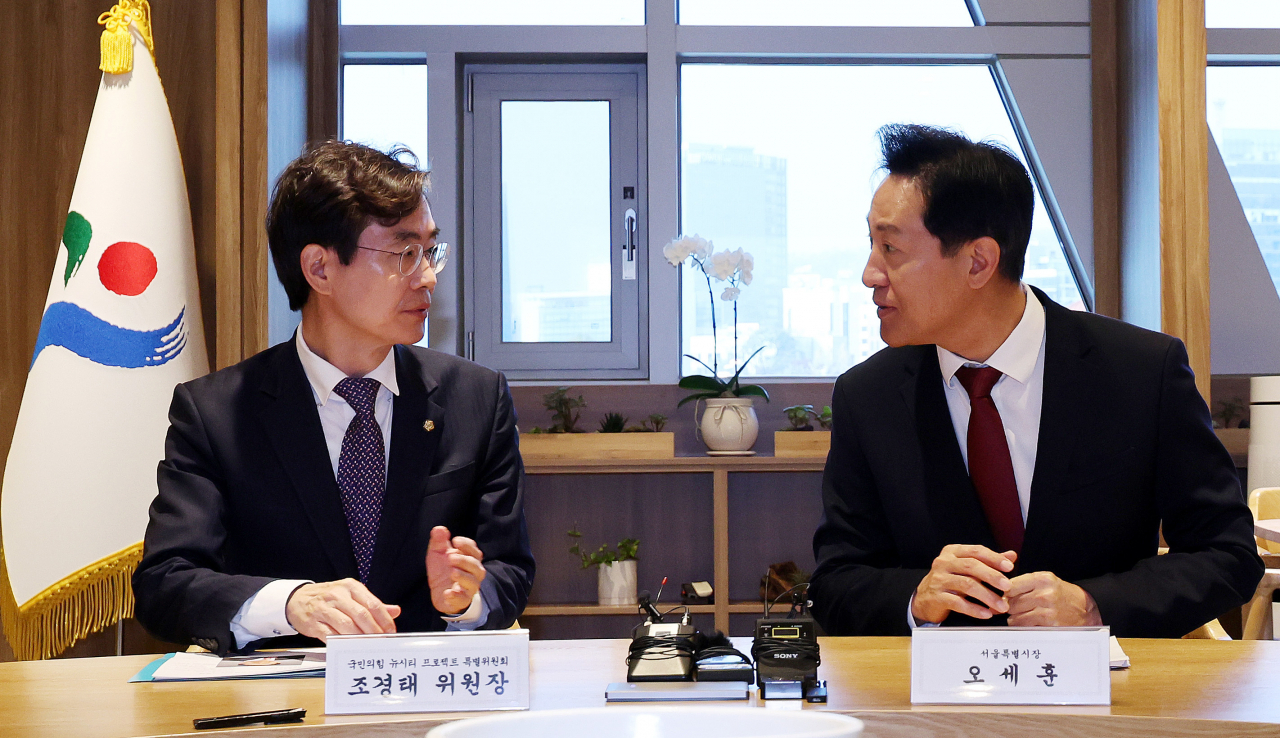 Seoul Mayor Oh Se-hoon (right) meets with Rep. Cho Kyoung-tae, head of the People Power Party's New City Project Special Committee, to discuss the incorporation of Gyeonggi provincial cities into Seoul at Seoul City Hall on Wednesday. (Yonhap)