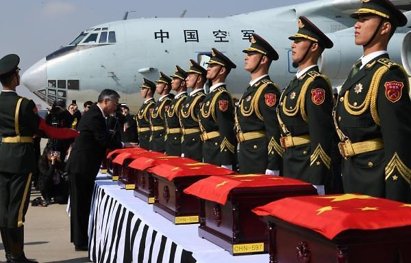 Chinese Ambassador to South Korea Qiu Guohong drapes a Chinese flag over a box containing the remains of a Chinese soldier killed in the 1950-53 Korean War at Incheon International Airport, west of Seoul, on April 3, 2019. (Yonhap)