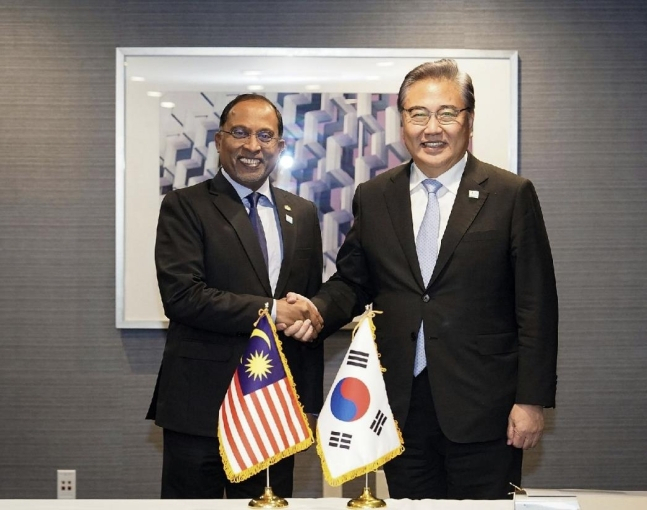 South Korea's Foreign Minister Park Jin (right) and Malaysian Foreign Minister Zambry Abdul Kadir (left) pose for a photo after a meeting on Tuesday, on the margins of APEC ministerial meeting. (Yonhap)