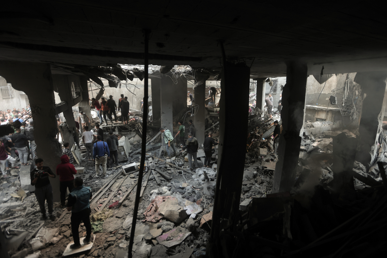 Palestinians look for survivors inside the remains of a destroyed building following an Israeli airstrike in Khan Younis refugee camp, southern Gaza Strip, Saturday. (AP-Yonhap)