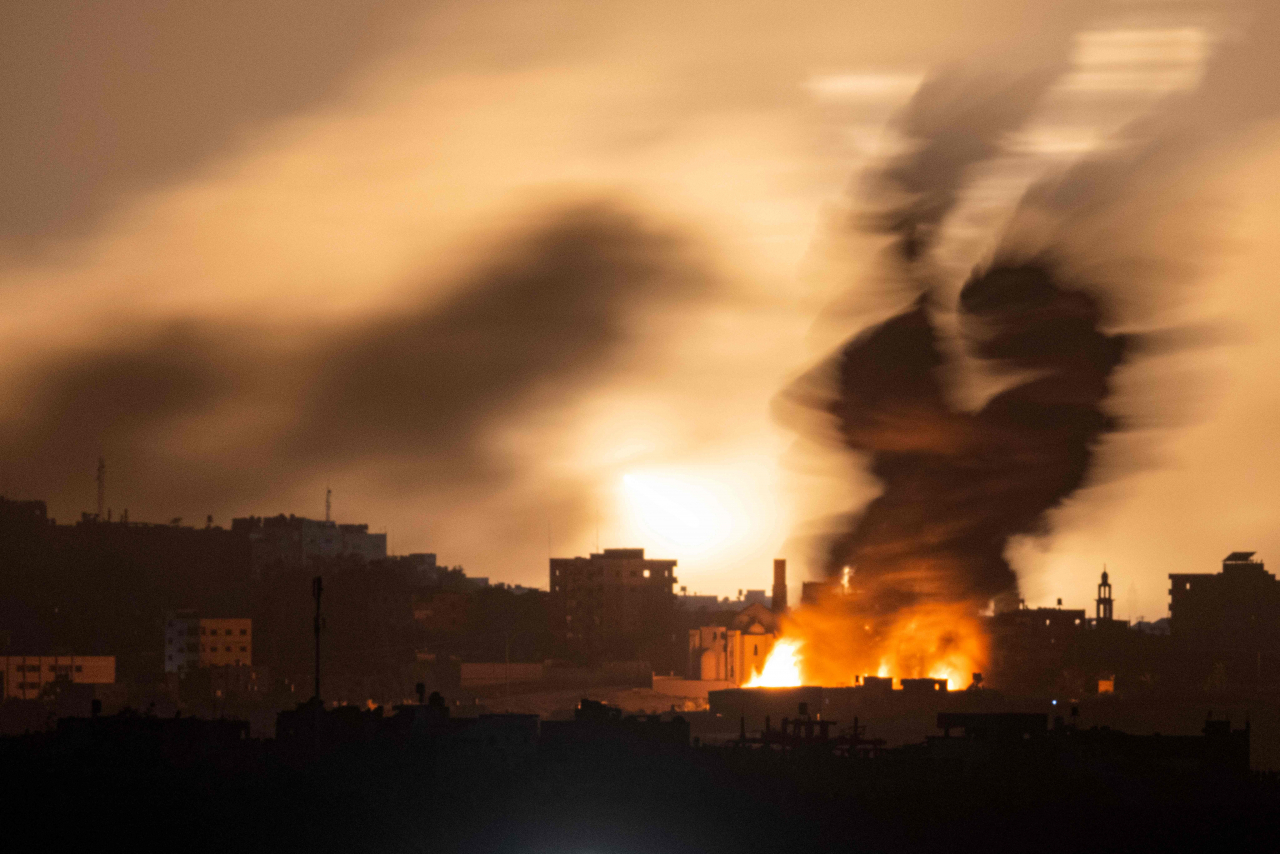 This picture taken from southern Israel shows a explosion lighting up the sky during an Israeli strike on the Gaza Strip early on Sunday (local time). (AFP-Yonhap)