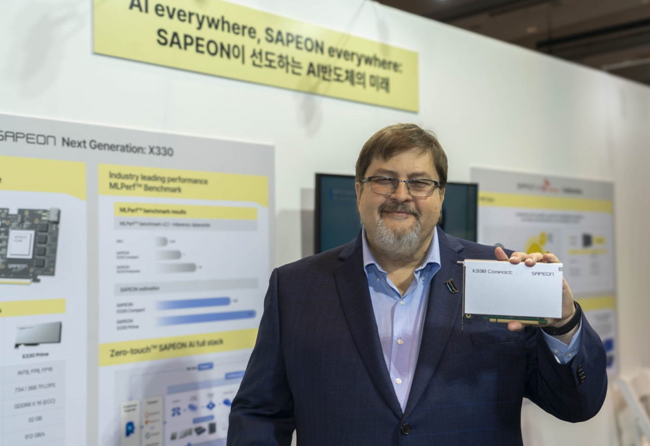 Sapeon Chief Technology Officer Michael Shebanow poses for a photo with the company's latest X330 compact card at the SK Tech Summit 2023 in Seoul on Thursday. (Sapeon)