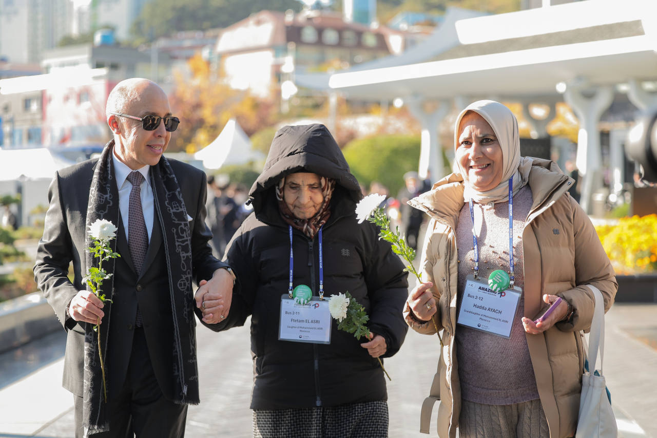 Ftetam El Asry, daughter of a Moroccan soldier named Mohamed El Asry(center) and Moroccan Ambassador to Korea Chafik Rachadi(first from left) pay tribute to a Moroccan soldier who sacrificed his life in the Korean War at the UN Cemetery in Busan on Nov. 11. (Moroccan Embassy in Seoul)