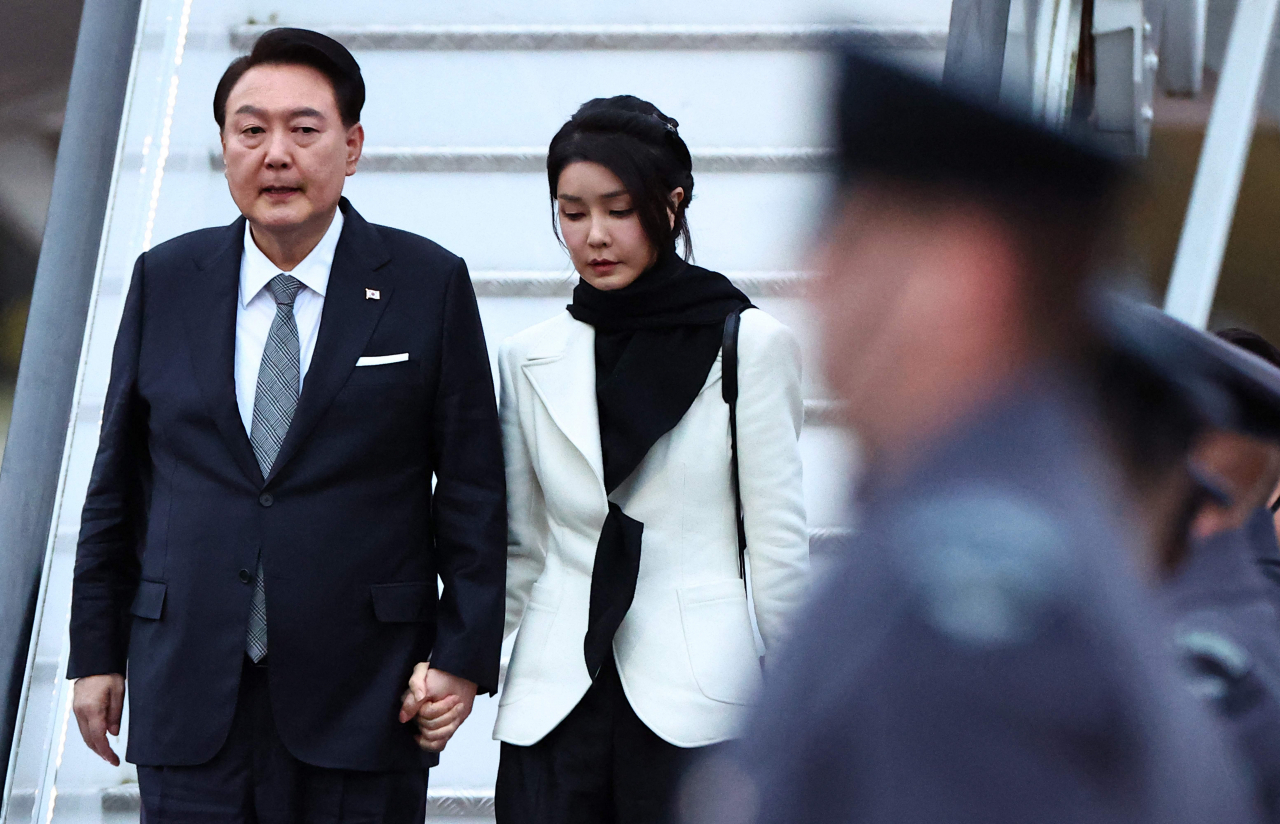 South Korea's President Yoon Suk Yeol and his wife Kim Keon-hee disembark from an aircraft after landing at London Stansted Airport. (AFP-Yonhap)