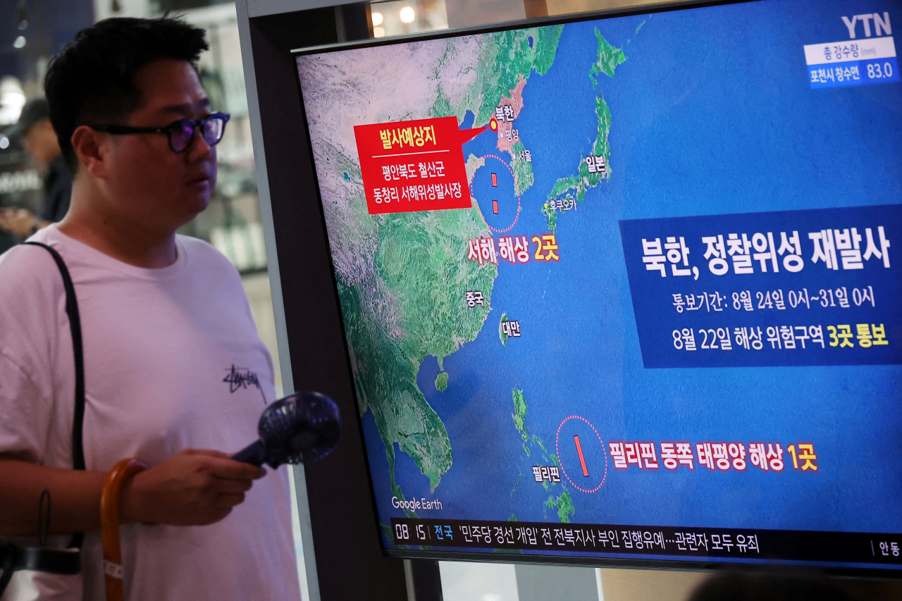A man walks past a TV broadcasting a news report on North Korea firing a space rocket, at a railway station in Seoul, South Korea, August 24. (Reuters)