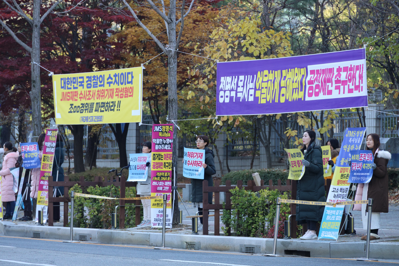 Followers of the Jesus Morning Star religious movement organization stand outside Daejeon District Court to protest against the court trial of Jeong Myeong-seok, leader of JMS, Tuesday. (Yonhap)
