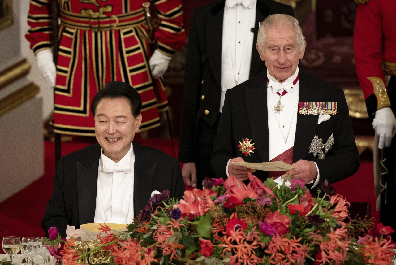 President of South Korea Yoon Suk Yeol (left) listens as King Charles III speaks at the state banquet at Buckingham Palace, London, Tuesday. (Pool photo via AP-Yonhap)