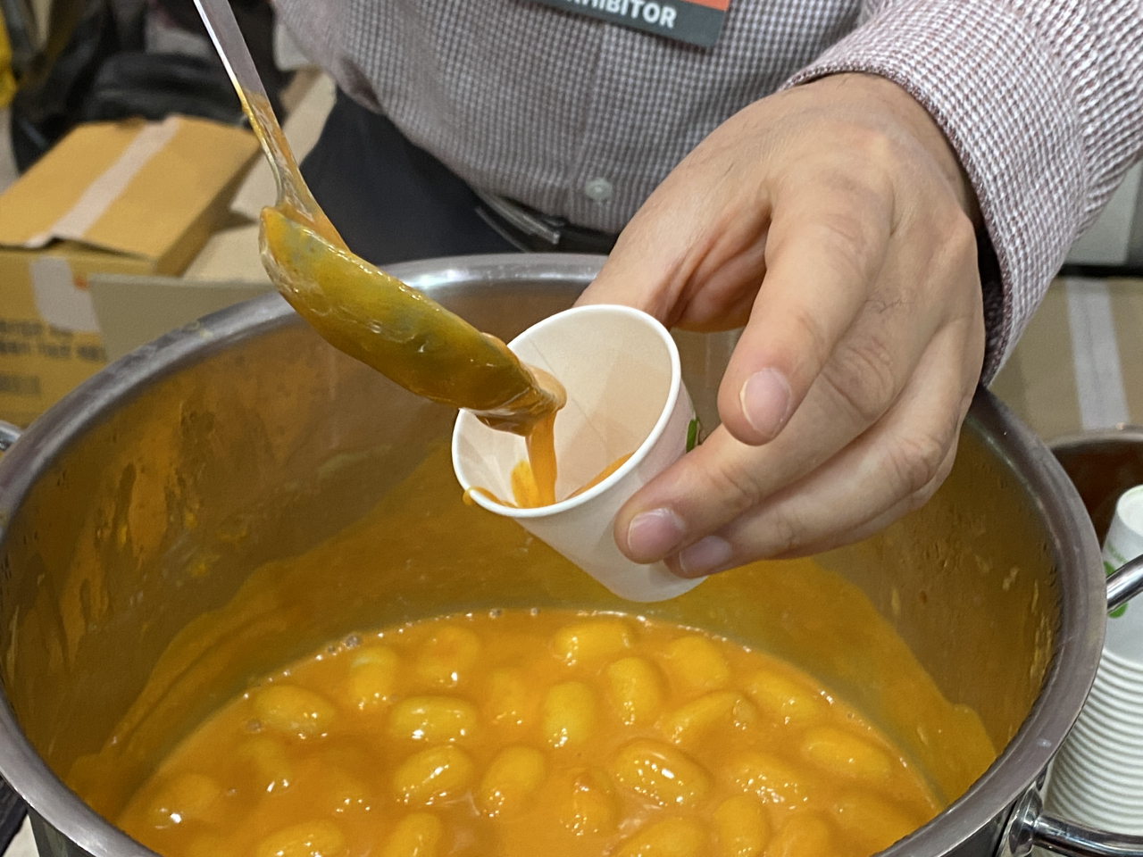 Misslee tteokbokki is ladled into a disposable paper cup at 2023 Coex Food Week, held at Coex in southern Seoul, Wednesday. (Hwang Joo-young/The Korea Herald)