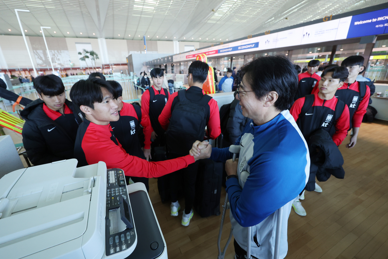 Hwang Sun-hong (right), head coach of the South Korean men's national under-23 football team, shakes hands with his players at Incheon International Airport on Nov. 13. (Yonhap)