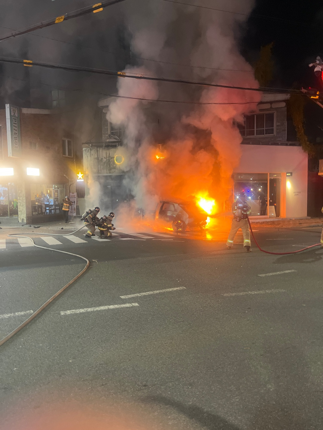 Firefighters put out an electric taxi on fire Wednesday in Busan. (Busan Metropolitan City Fire Disaster Headquarters)