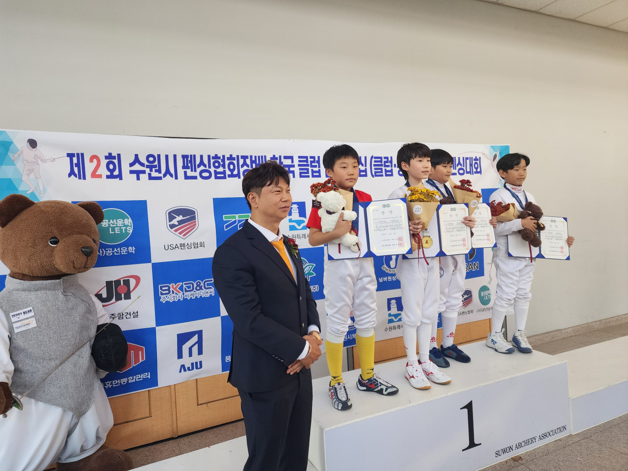 An Jae-cheon(left), president of BK D&C, poses with the top contestants in the elementary school division of the Korea Club Championship – Fencing, that took place Nov.11-12 in this file photo. (Suwon Fencing Association)