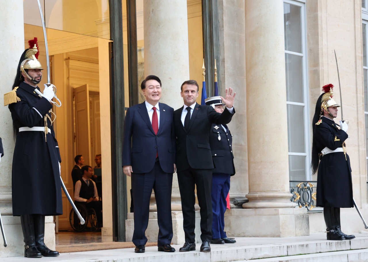 South Korean President Yoon Suk Yeol (4th from L) shakes hands with French President Emmanuel Macron (5th from L) prior to their breakfast and summit meeting at Elysee Palace in Paris on Friday. (Yonhap)