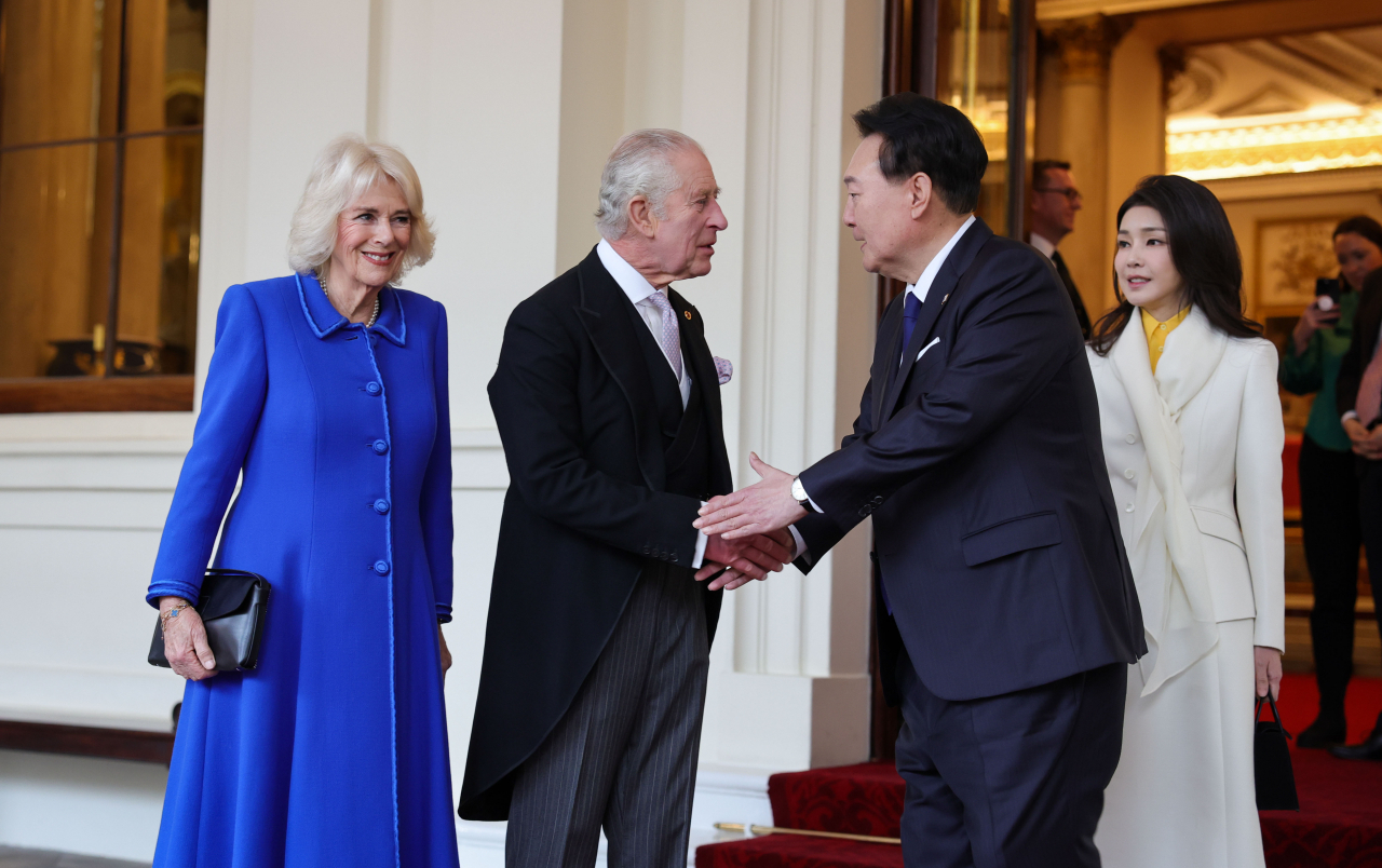 South Korean President Yoon Suk Yeol (3rd from left) shakes hands with Britain's King Charles III, watched by first lady Kim Keon Hee (right) and Britain's Queen Camilla, during a formal farewell at Buckingham Palace in London on Thursday, on his last day of a four-day state visit to the European country. (Yonhap)