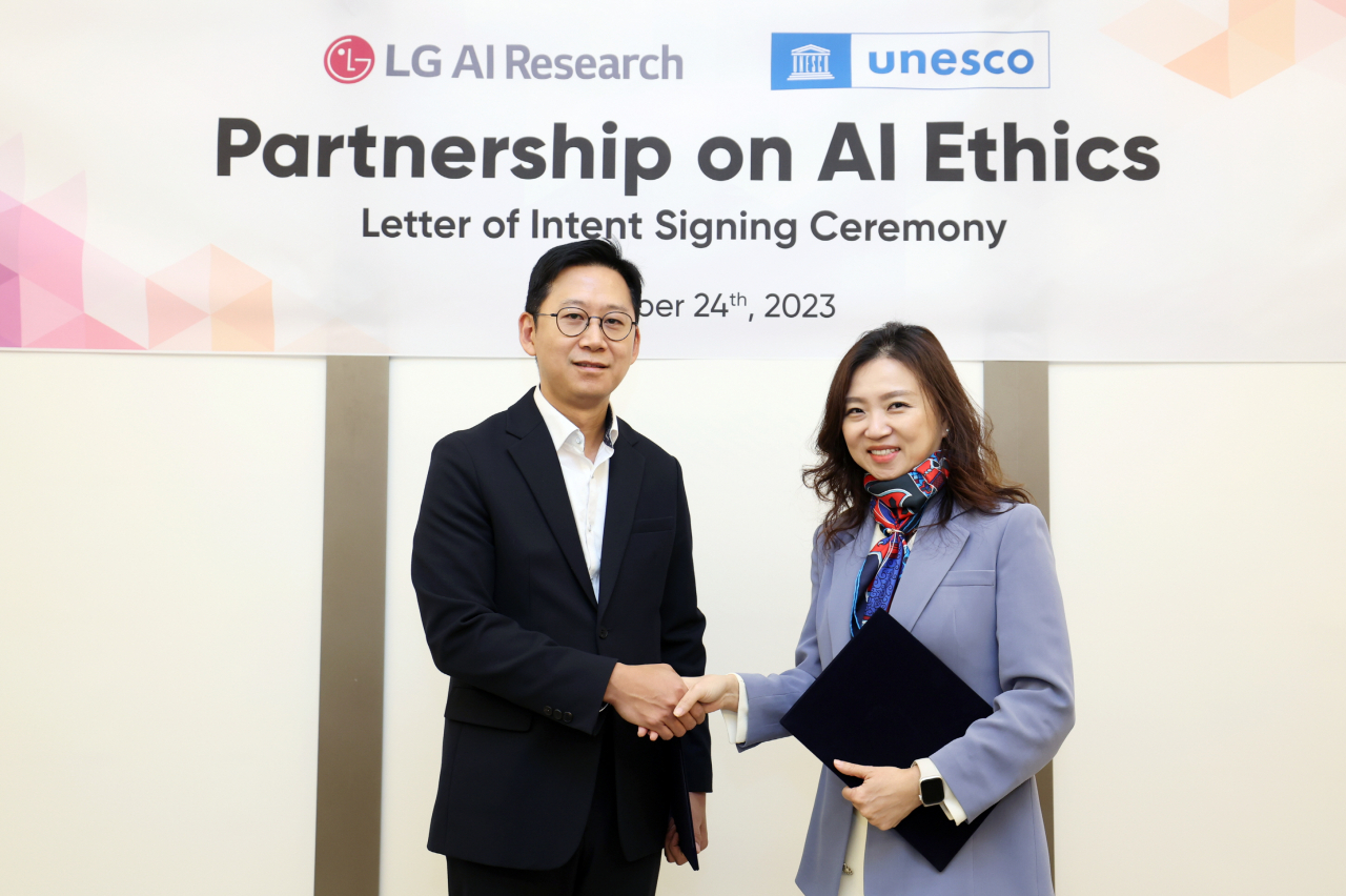 Bae Kyung-hoon, chief of LG AI Research (left), shakes hands with Kim Soo-hyun, director of the UNESCO Asia and Pacific Regional Bureau, after signing a letter of intent on an AI ethics partnership at LG Science Park in Seoul on Friday. (LG Corp.)