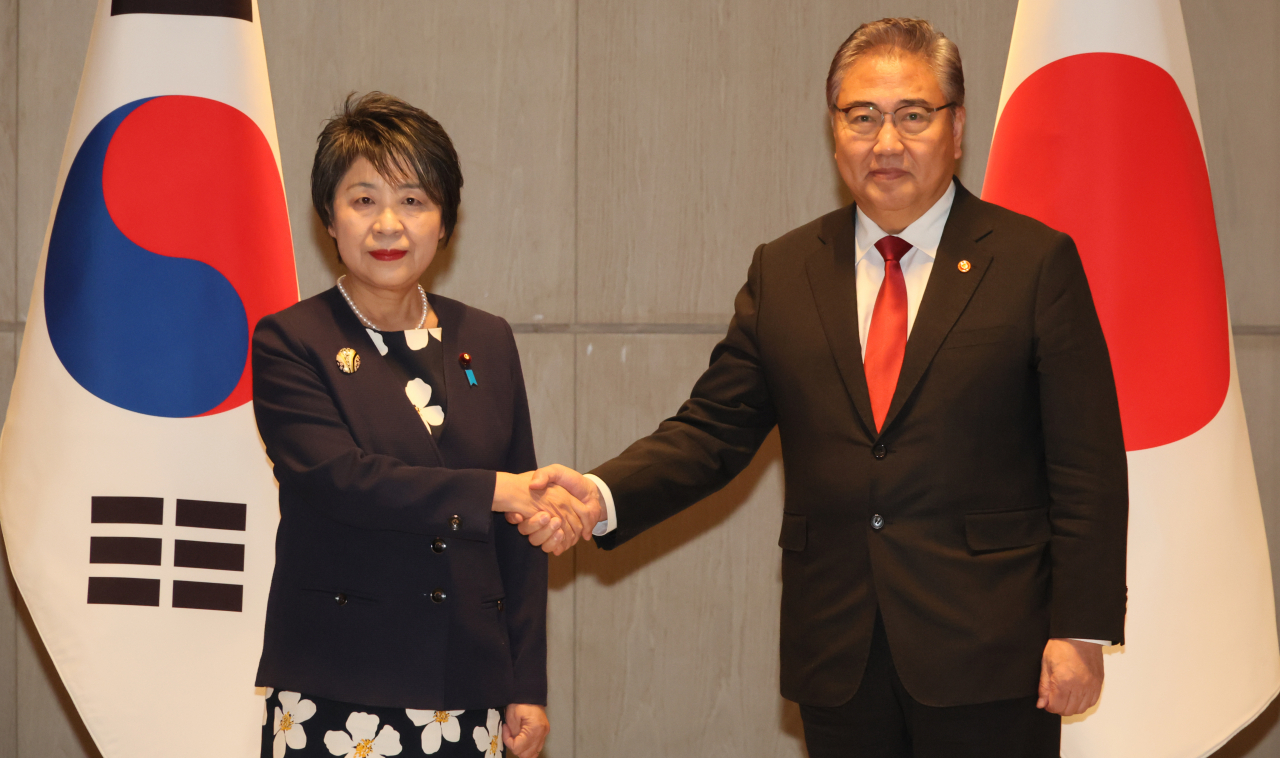 Foreign Minister Park Jin (right) shakes hands with Japanese Foreign Minister Yoko Kamikawa ahead of their bilateral talks at a hotel in Busan Monday, where they gathered to hold trilateral talks with their Chinese counterpart, Wang Yi, later in the day. (Yonhap - Pool Photo)