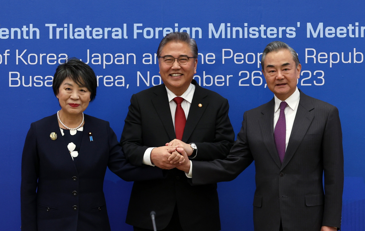 South Korean Foreign Minister Park Jin (center) poses for a photo with Chinese Foreign Minister Wang Yi (right) and Japanese Foreign Minister Yoko Kamikawa before their trilateral talks in the southeastern port city of Busan on Sunday. (Yonhap)
