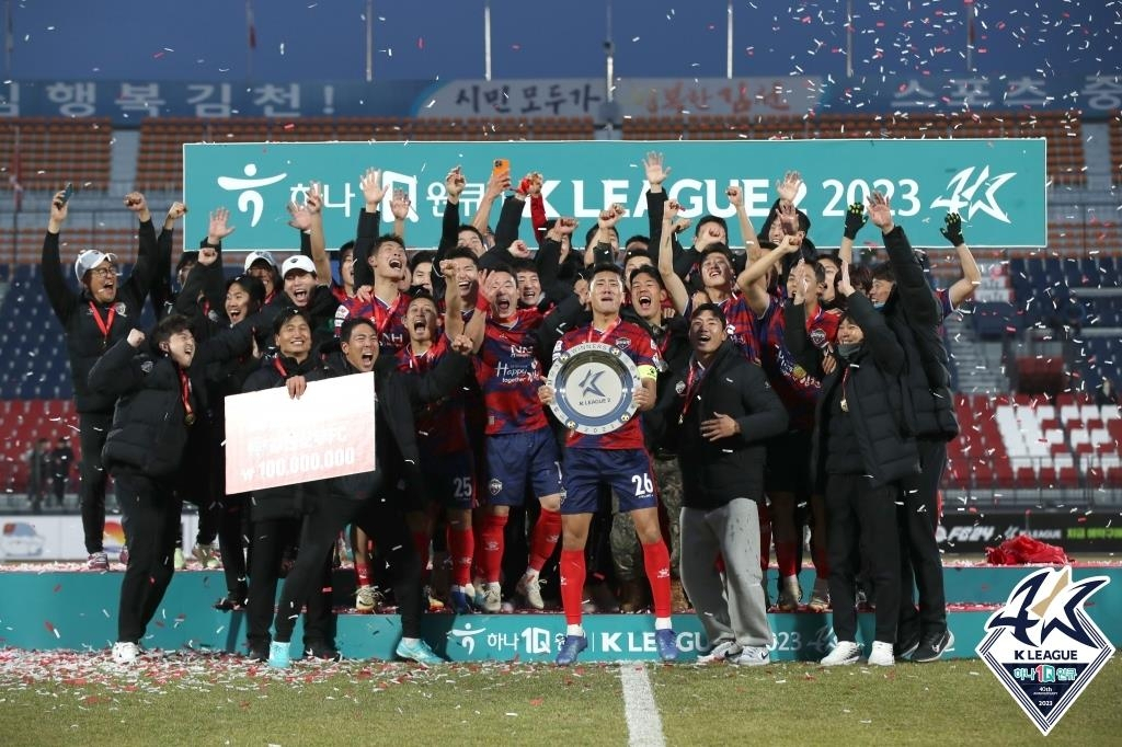 Gimcheon Sangmu FC players and coaches celebrate earning a promotion to the K League 1 for 2024 following their 1-0 win over Seoul E-Land FC 1-0 in their K League 2 match at Gimcheon Stadium in Gimcheon, North Gyeongsang Province, on Sunday, in this photo provided by the Korea Professional Football League.