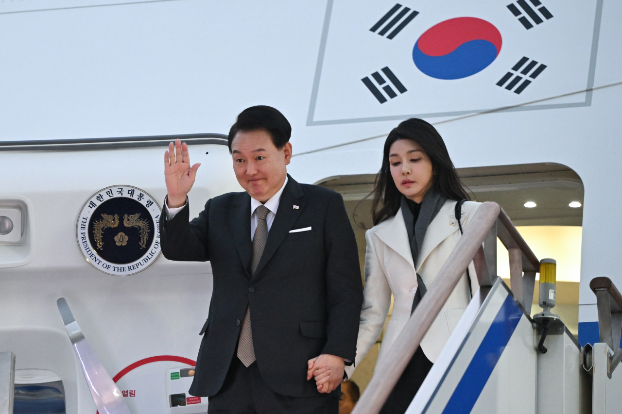 President Yoon Suk Yeol (left), alongside his wife, Kim Keon Hee, disembarks from the presidential plane at Seoul Air Base in Seongnam, south of Seoul, on Sunday, after finishing a two-nation visit that took him to Britain and France.