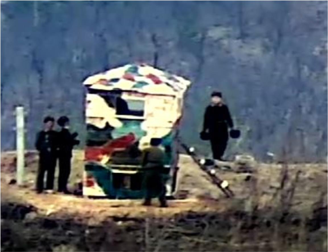 North Korean soldiers stand next to a newly erected wooden observation post painted with a camouflage pattern at the Demilitarized Zone in this photo provided by the Ministry of National Defense on Monday. Previously at the site, a post had been demolished in accordance with a 2018 military agreement. The Defense Ministry announced that the military has detected signs of North Korea having restored 11 guard posts in the Demilitarized Zone since Nov. 24. (Ministry of National Defense)