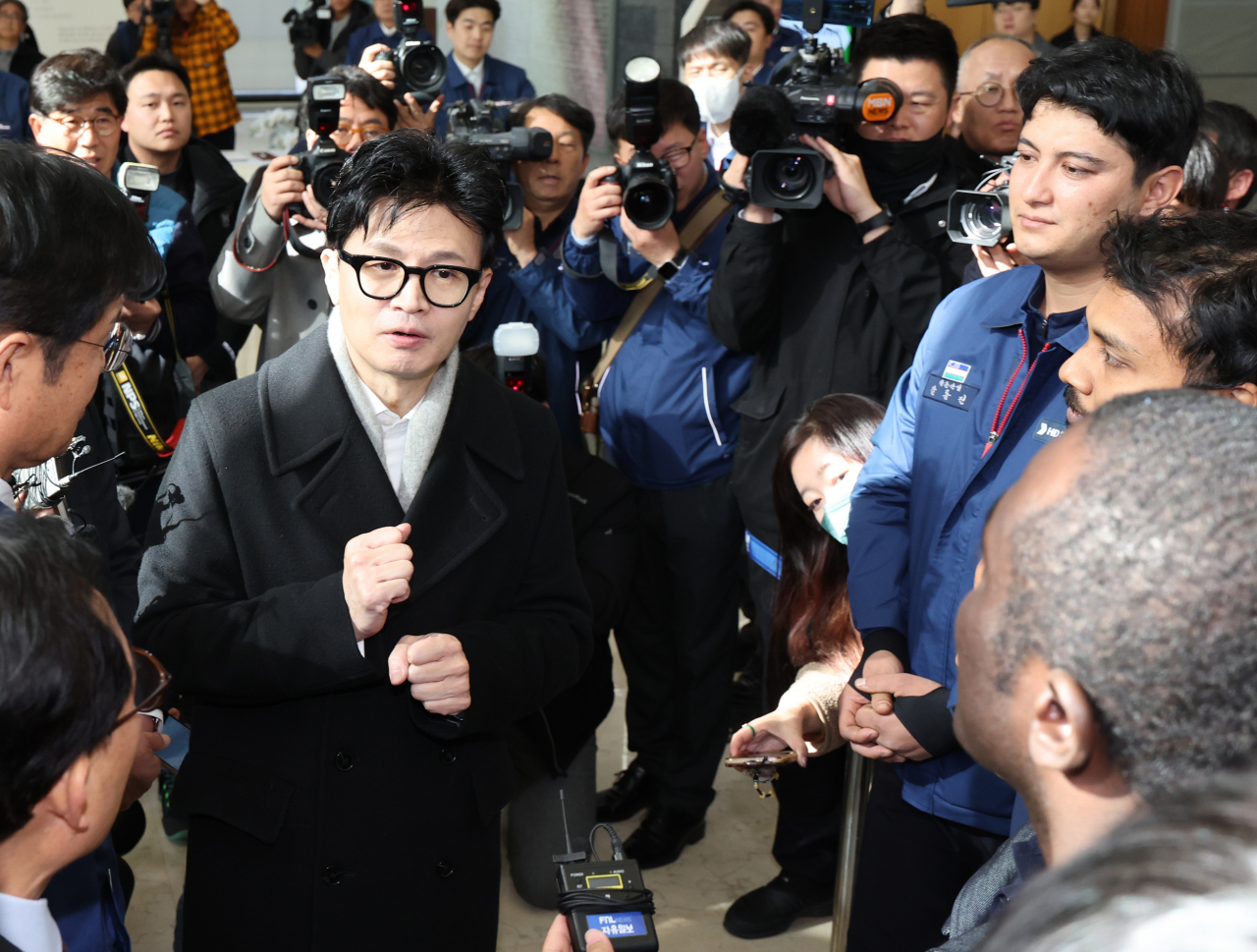 Justice Minister Han Dong-hoon talks to foreign workers at HD Hyundai Heavy Industries headquarters in Ulsan on Nov. 24. (Yonhap)