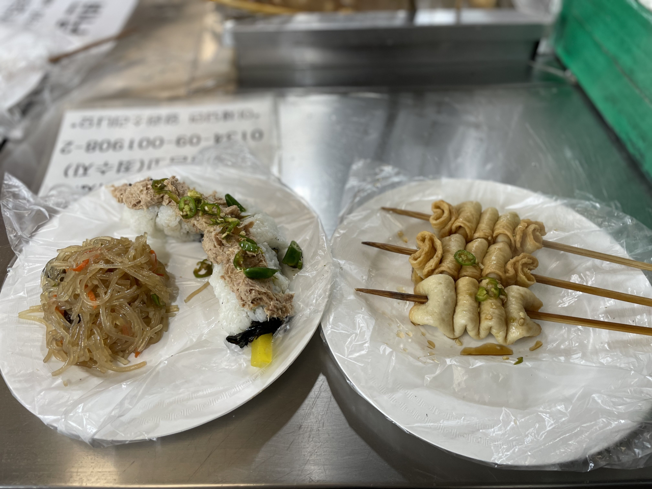 From left: Japchae, nude gimbap and fish cake on skewers at Gwangjang Market (Kim Da-sol/The Korea Herald)