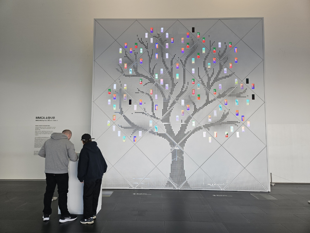 Visitors to MMCA Seoul type in a message to decorate the MMCA Wishing Tree on Friday. (Park Yuna/The Korea Herald)