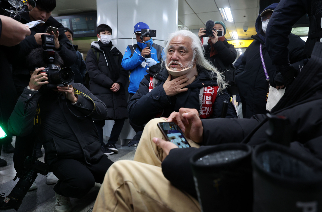 Park Kyeong-seok, head of Solidarity Against Disability Discrimination, attempts to enter Hyehwa Station on Line No. 4 to conduct silent protests for mobility rights for the disabled, Friday. (Newsis)