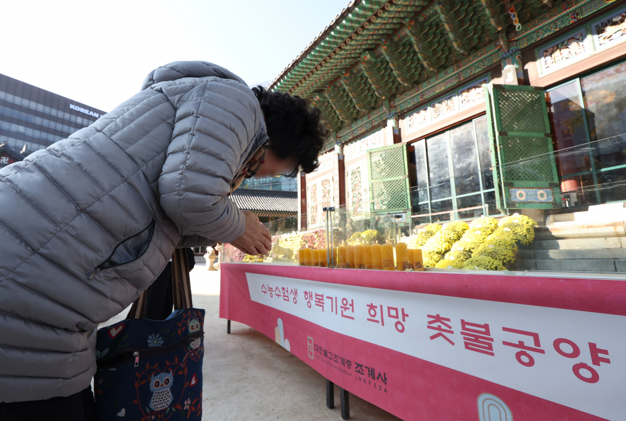 Four days before the 2024 college entrance examination, citizens pray in front of the main hall of Jogyesa Temple in Jongno-gu, Seoul on Nov. 12. (Yonhap)